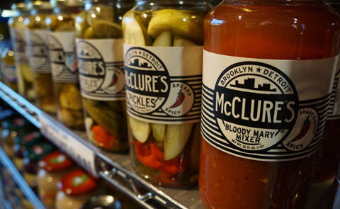 Bloody Mary Mix Bottles next to pickles on a shelf